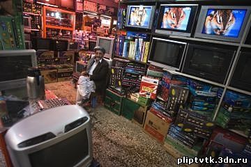 На архивном фото: Торговец в магазине телевизоров и спутниковых ресиверов в афганском Герате (2009 год).